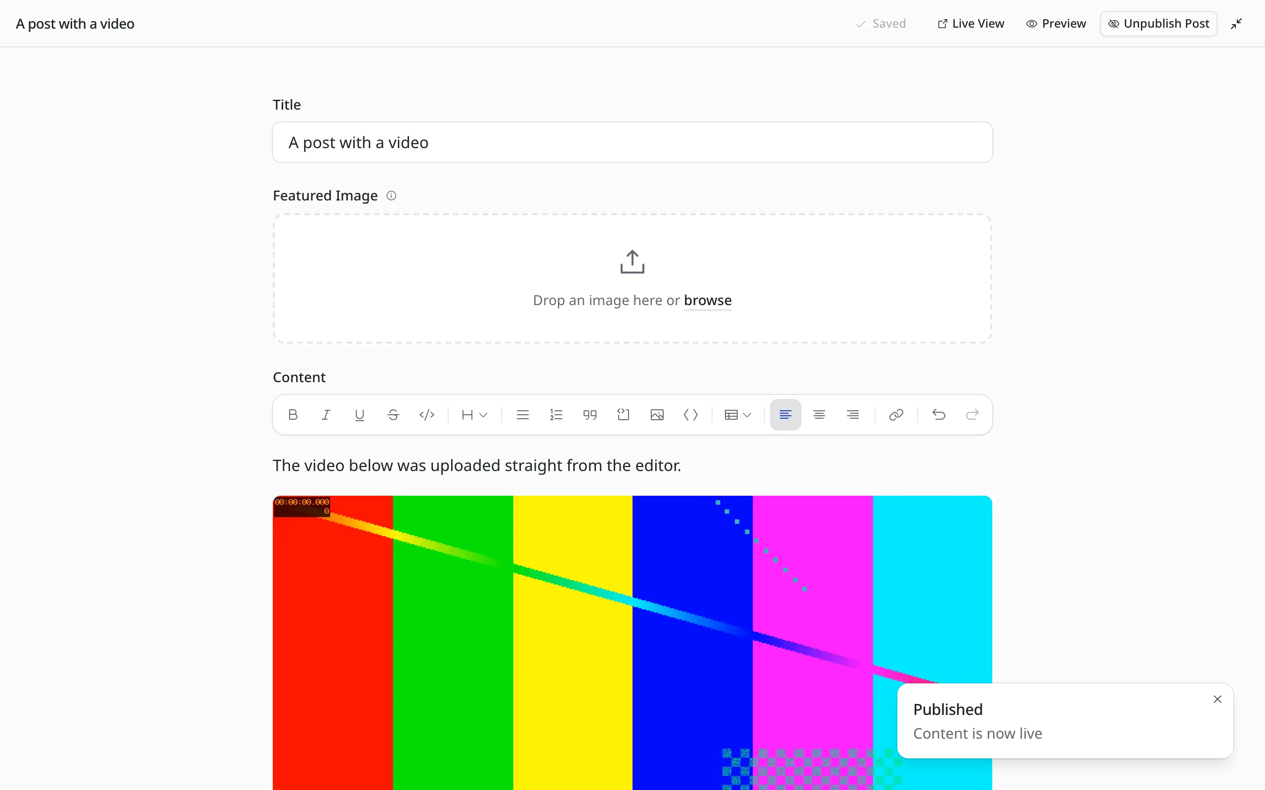 The EmDash editor in distraction-free mode. At the top a slim bar with the title "A post with a video", the status Saved and the buttons Live View, Preview and Unpublish Post. Below, centred, the title, featured image and text with an embedded video. Bottom right the notice "Published".